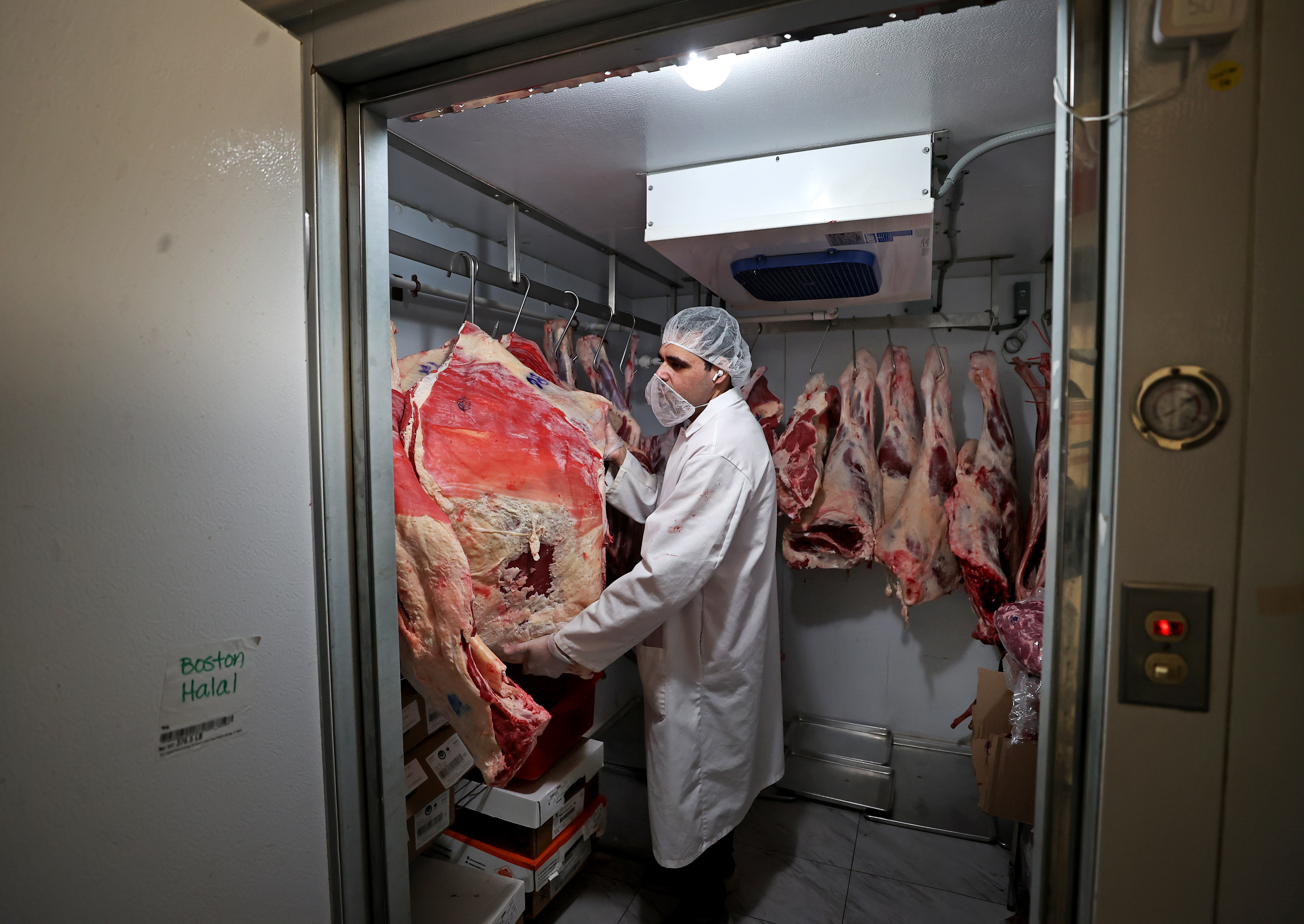 Butcher in the cold room at Halal Meat Boston in Quincy