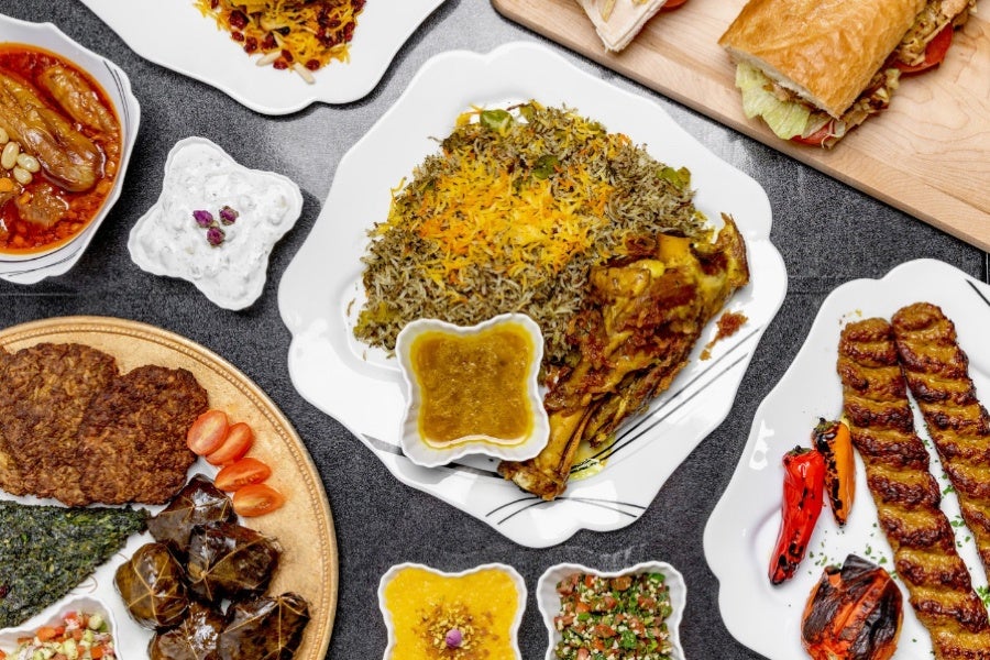 Café Vanak Persian dishes including saffron rice, lamb shank, grilled kebabs, stuffed grape leaves, and salads.