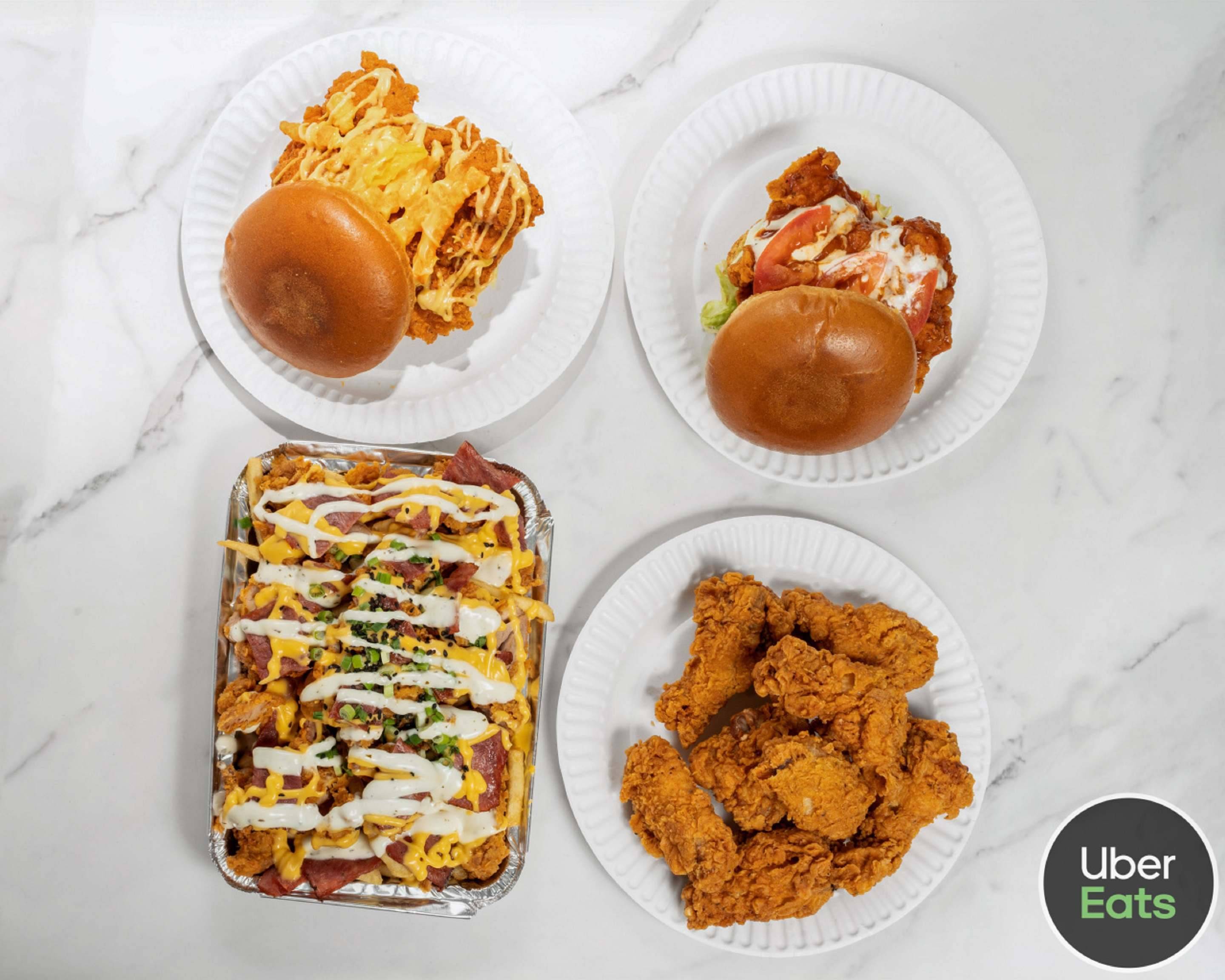 Side Chick fried chicken tenders, chicken sandwiches, and loaded fries on a white counter